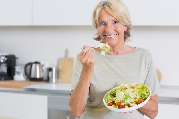 Foto sonriente mujer comiendo ensalada