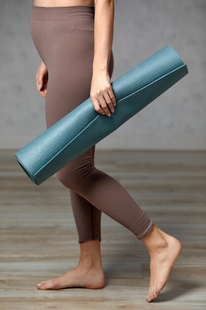 Foto sonriente mujer embarazada en ropa deportiva lista para gimnasia matutina o ejercicio mujer joven feliz seguir un estilo de vida saludable durante el embarazo sostener estera de yoga para pilates o estiramientos