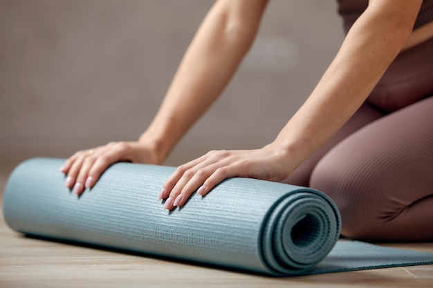 Sonriente mujer embarazada en ropa deportiva lista para gimnasia matutina o ejercicio Mujer joven feliz seguir un estilo de vida saludable durante el embarazo sostener estera de yoga para Pilates o estiramientos