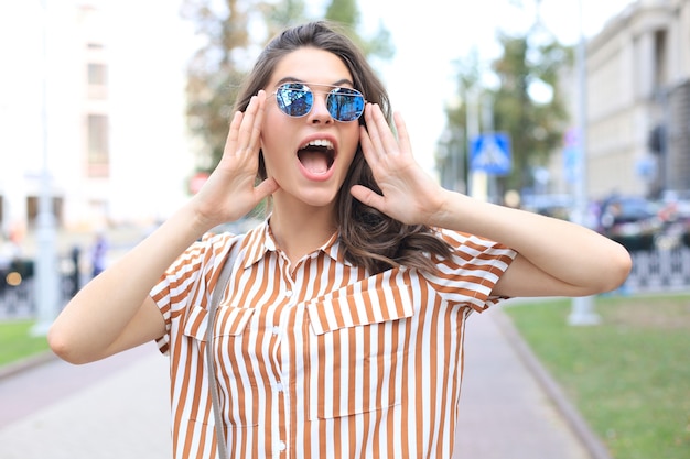 Sonriente mujer hermosa joven feliz caminando al aire libre.