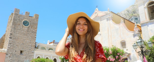 Sonriente mujer hermosa en la plaza principal de Taormina. Chica turista visitando hito italiano en la isla de Sicilia.
