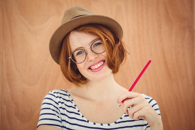 Sonriente mujer hipster con una pluma