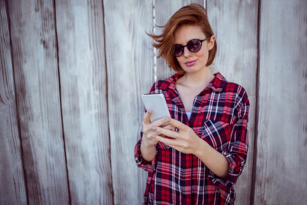 sonriente mujer hipster en su teléfono inteligente