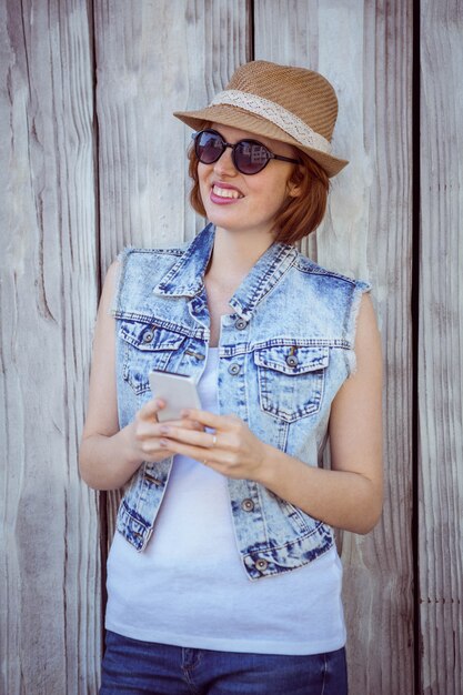 sonriente mujer hipster en su teléfono inteligente