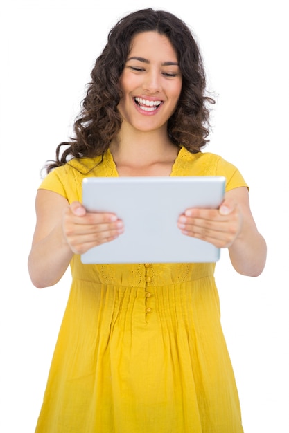 Sonriente mujer joven casual sosteniendo su tableta