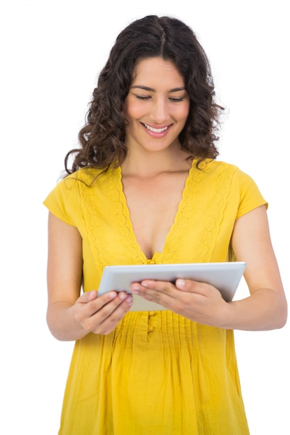Sonriente mujer joven casual usando su tableta