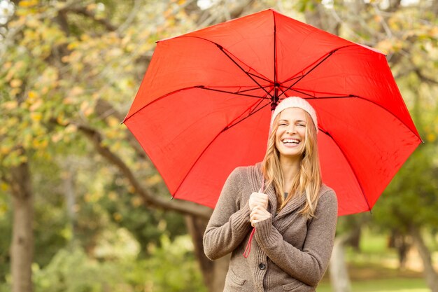 Sonriente, mujer joven, debajo, paraguas