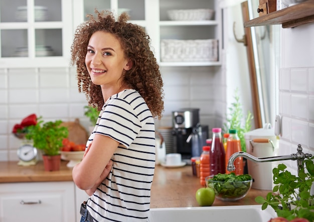 Sonriente, mujer joven, en, ella, cocina