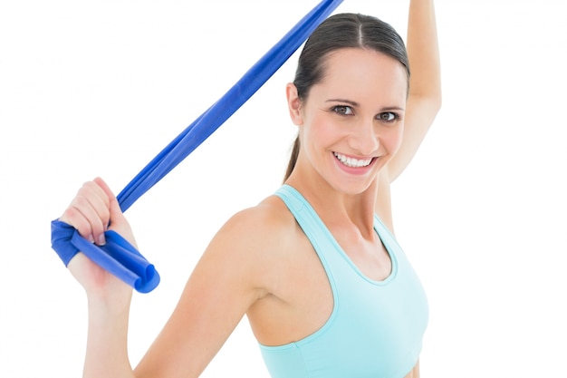 Sonriente mujer joven en forma con cinturón azul de yoga