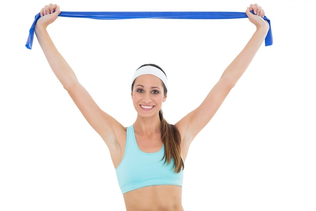 Sonriente mujer joven en forma con un cinturón de yoga azul