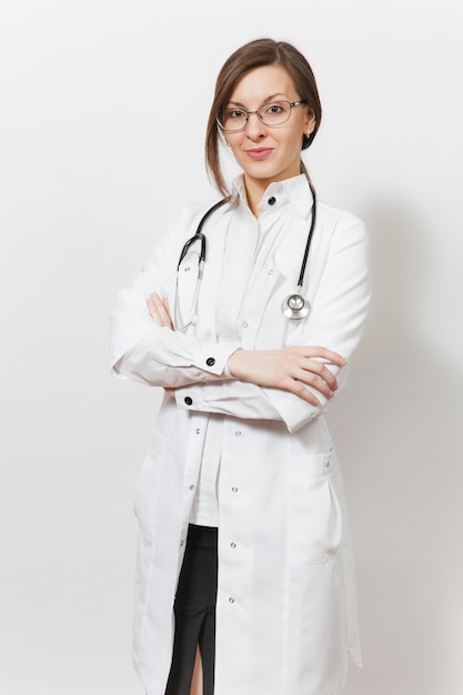 Sonriente mujer joven hermosa confiada médico con estetoscopio, gafas aisladas sobre fondo blanco. Doctora en bata médica tiene las manos juntas. El personal sanitario, la salud, el concepto de medicina.