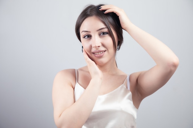 Sonriente a mujer joven hermosa con la piel limpia y fresca