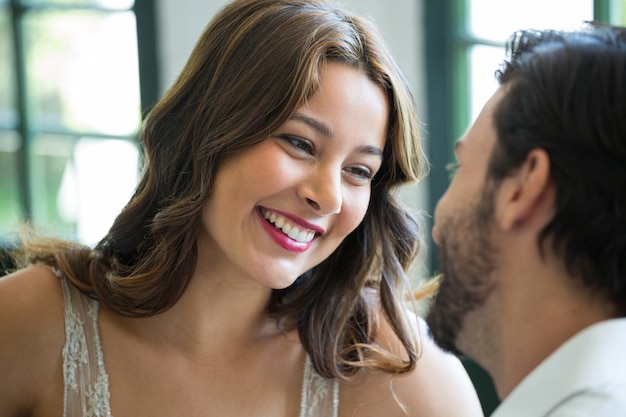 Sonriente, mujer joven, mirar al hombre, en, restaurante