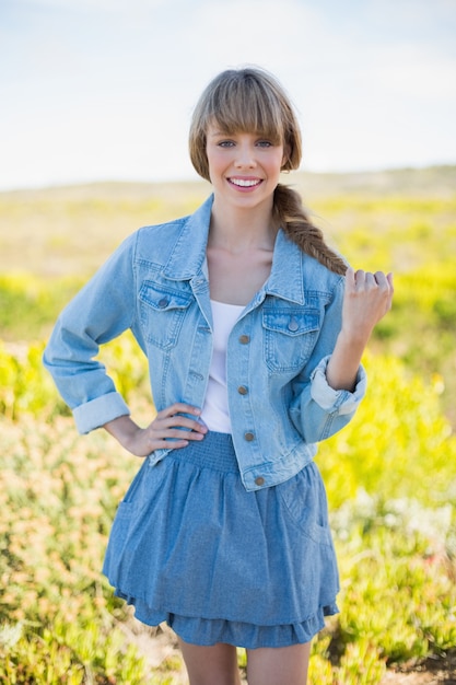 Sonriente mujer joven de moda posando