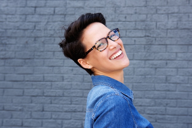 Sonriente mujer joven con pelo corto y gafas