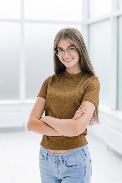 Sonriente, mujer joven, posición, en, brillante, oficina