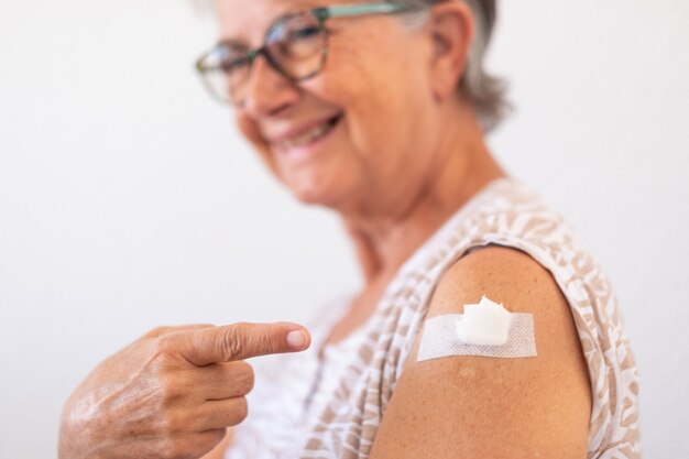 Sonriente mujer mayor de 70 años después de recibir la vacuna contra el coronavirus covid-19.