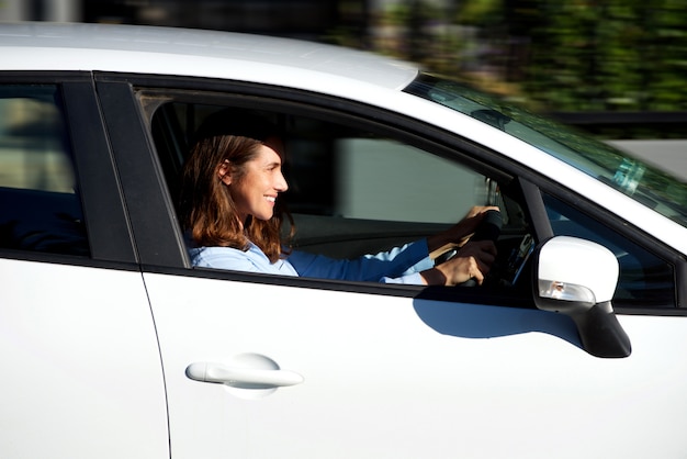 Sonriente mujer mayor conduciendo coche