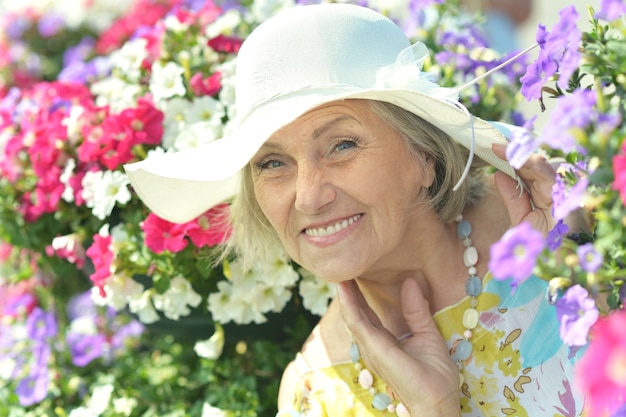 Sonriente mujer mayor sobre un fondo floral