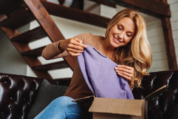 Sonriente mujer de mediana edad cliente recibe paquete en casa concepto de entrega de pedidos de compras en línea