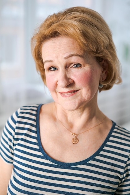 Sonriente mujer de mediana edad gris madura mirando a la cámara feliz anciana