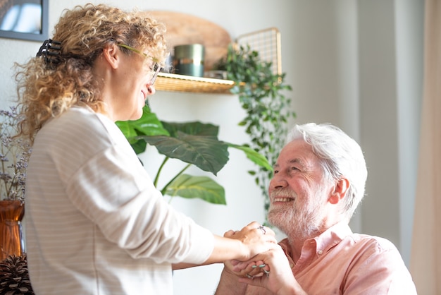 Sonriente mujer de mediana edad y padre senior pasar tiempo juntos en casa