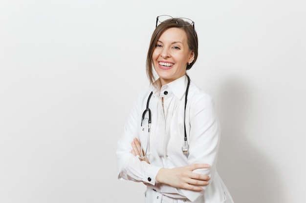 Sonriente mujer médico bastante joven confiada con estetoscopio, gafas aisladas sobre fondo blanco. doctora en bata médica cogidos de la mano cruzados. el personal sanitario, la salud, el concepto de medicina.