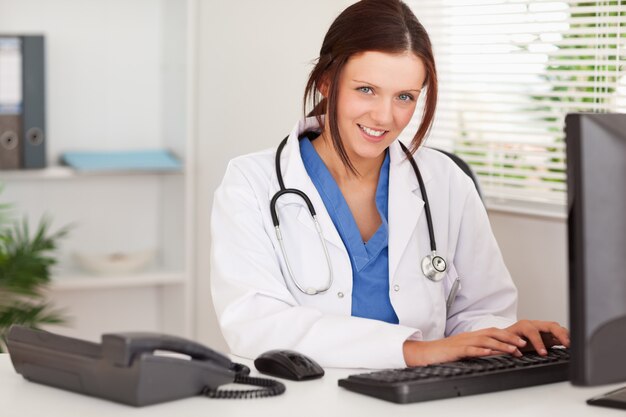 Sonriente mujer médico escribiendo