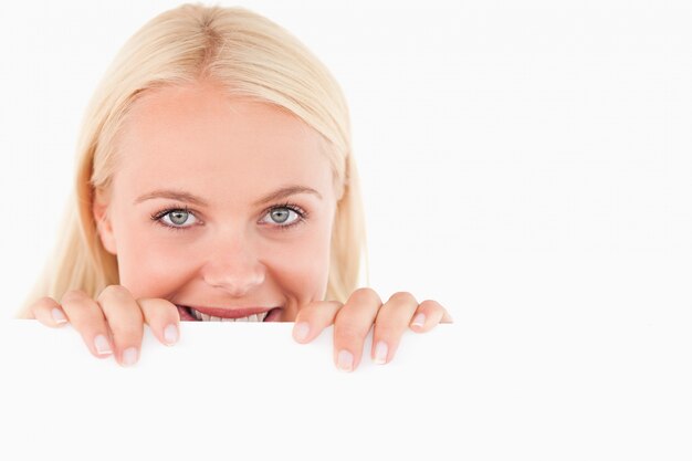 Sonriente mujer mirando a través de una pizarra