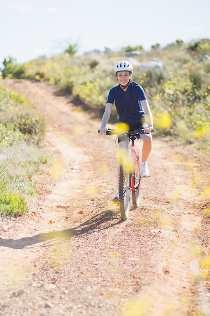 Sonriente mujer montando bicicleta