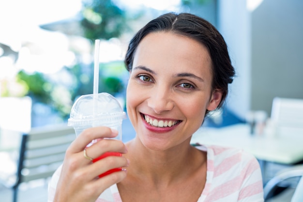 Sonriente mujer morena disfrutando de su batido