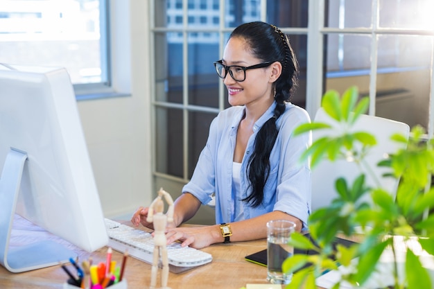 Sonriente mujer de negocios casual que trabaja en la computadora