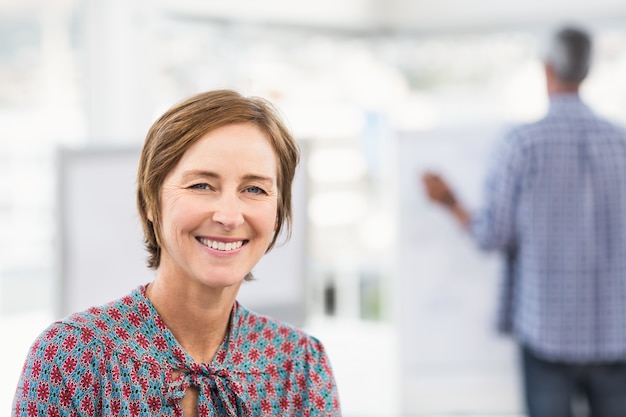 Sonriente mujer de negocios informal frente a colega