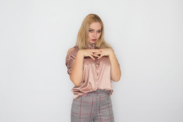 Sonriente mujer de negocios rubia en blusa rosa sobre fondo blanco.