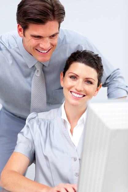 Sonriente mujer de negocios y su colleage trabajando en una computadora