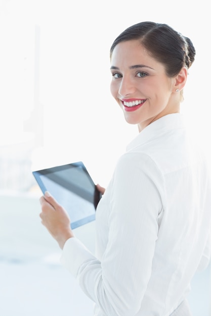 Sonriente mujer de negocios con tablet PC en la oficina