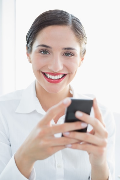 Sonriente mujer de negocios con teléfono móvil