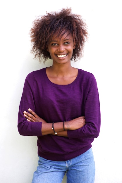 Sonriente mujer negra de pie contra el fondo blanco