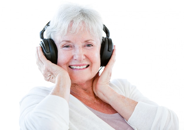 Sonriente mujer senior escuchando música con auriculares