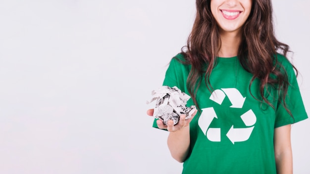 Foto sonriente mujer sosteniendo papel arrugado