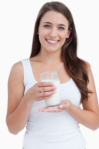 Sonriente mujer sosteniendo un vaso de leche