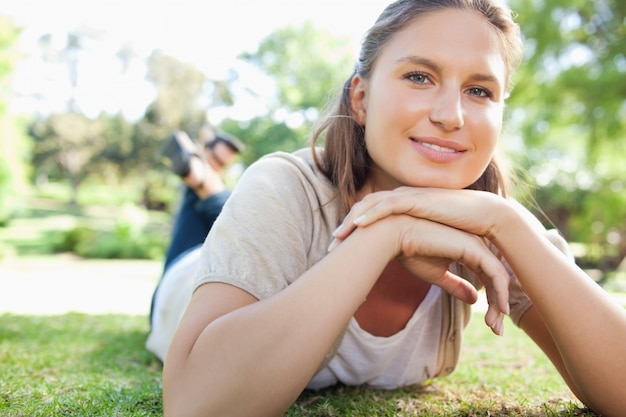 Foto sonriente mujer tendida en el césped