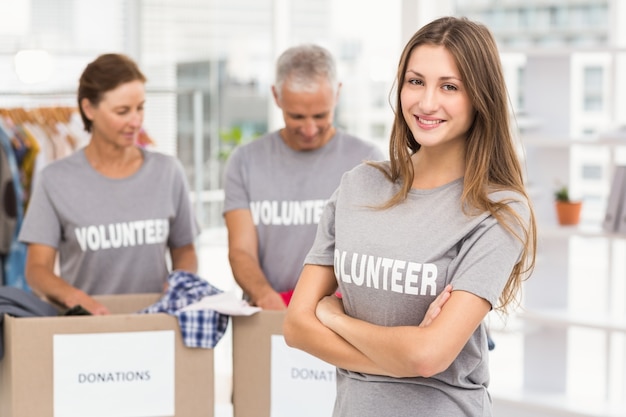 Sonriente mujer voluntaria con los brazos cruzados