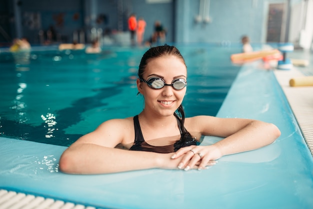 Gafas de natación y toalla colocadas en el puente de salida junto a la  piscina.