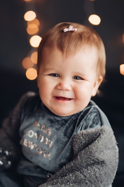 Sonriente niña linda gordita con un pequeño lazo rosa