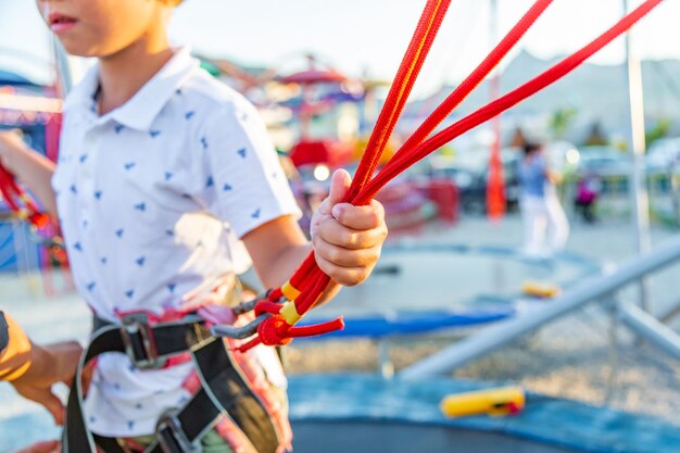 Sonriente niño emocionado saltando en un trampolín con seguro