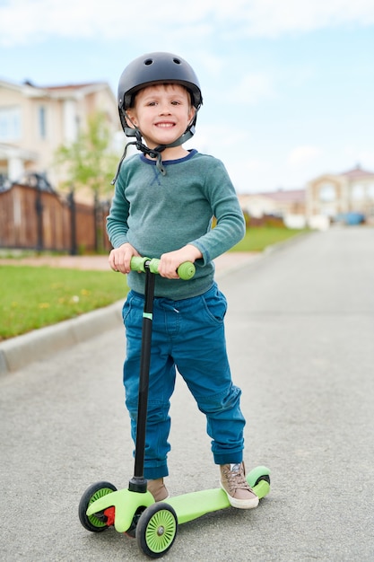 Sonriente, niño pequeño, equitación, patineta