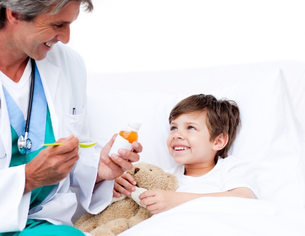 Sonriente niño tomando medicina para la tos