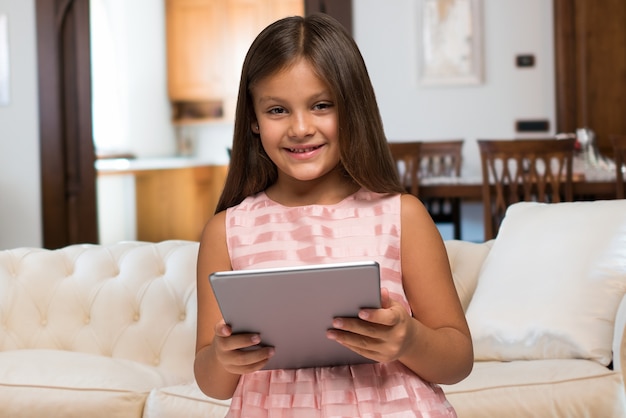 Sonriente niño usando una tableta en casa