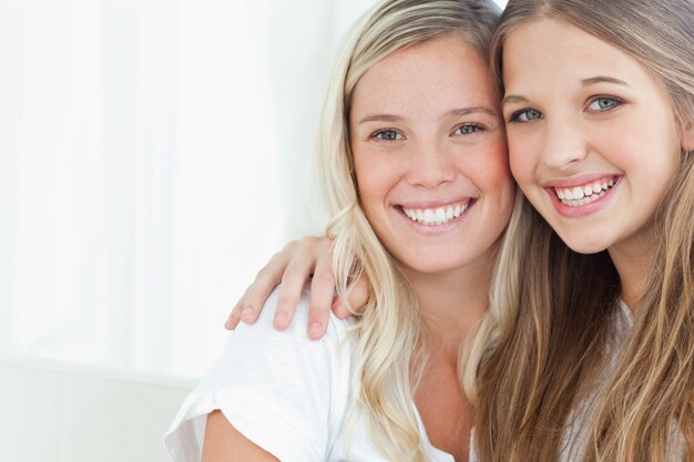 Un sonriente par de hermanas mirando a la cámara